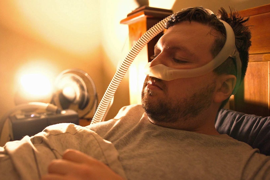 Jonathan Brown lies in bed with a tube attached to his nose.