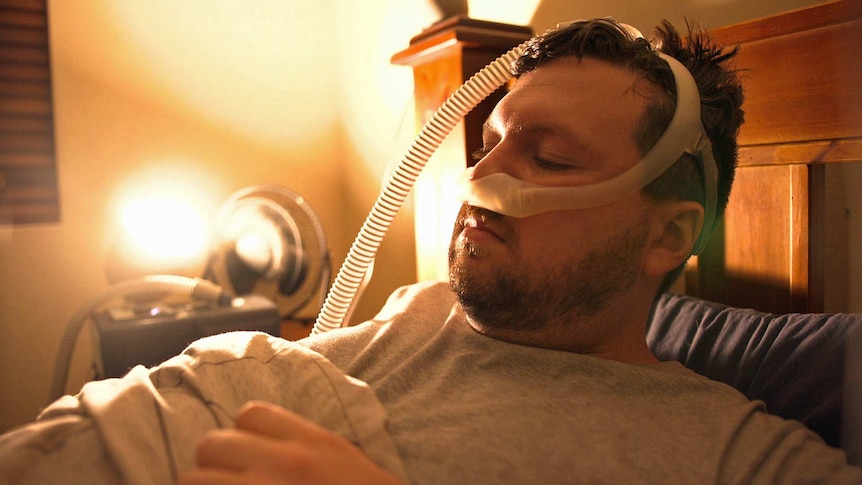 Jonathan Brown lies in bed with a tube attached to his nose.