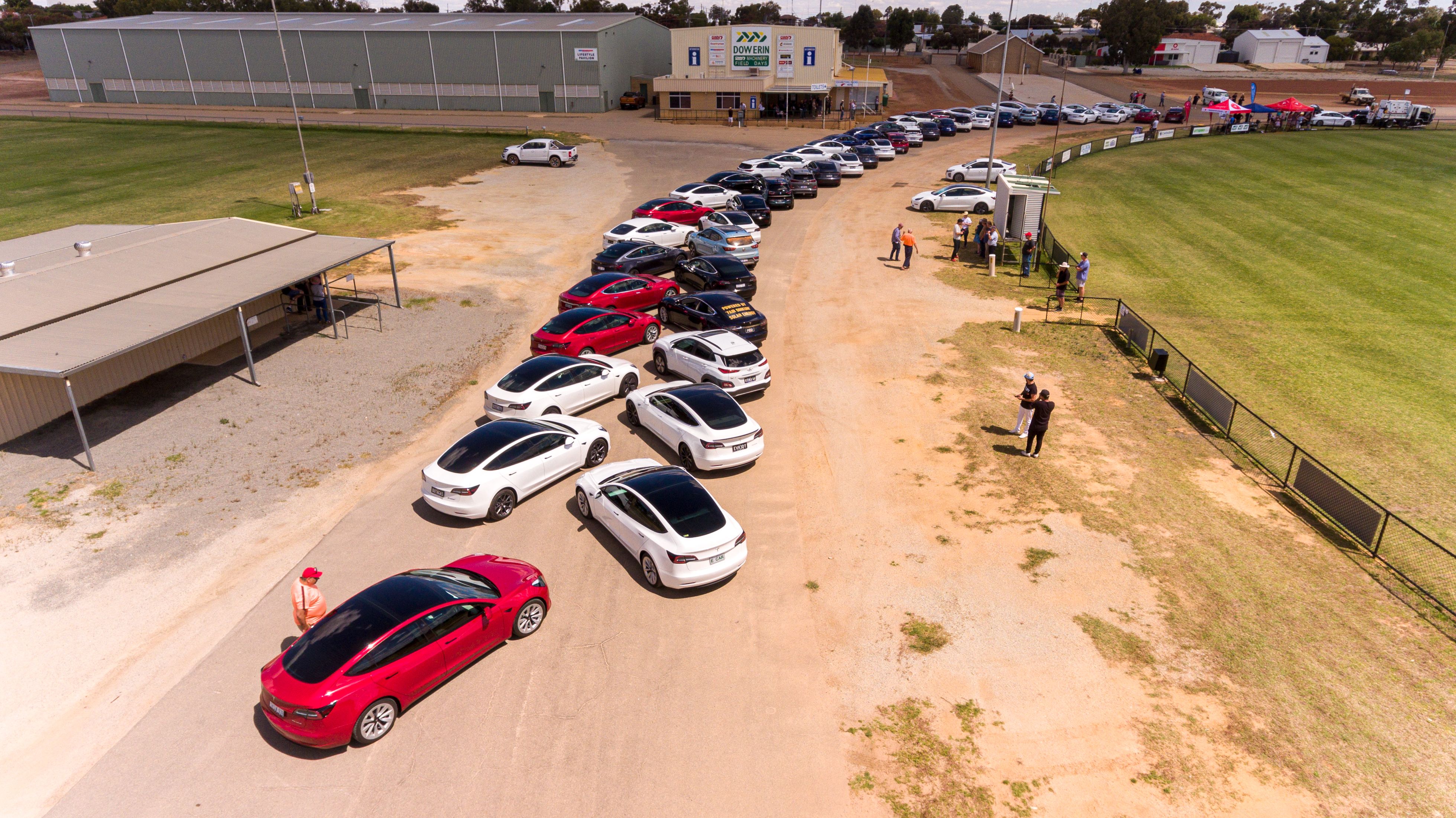 An aerial shot of cars parked around a footy oval