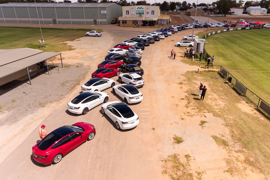 An aerial shot of cars parked around a footy oval