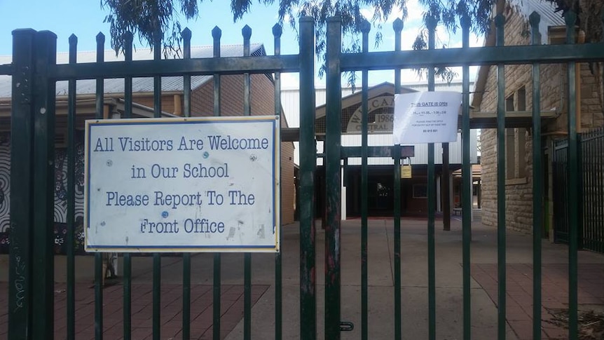 The front gate at Wilcannia Central School with a sign advising the gate is locked.