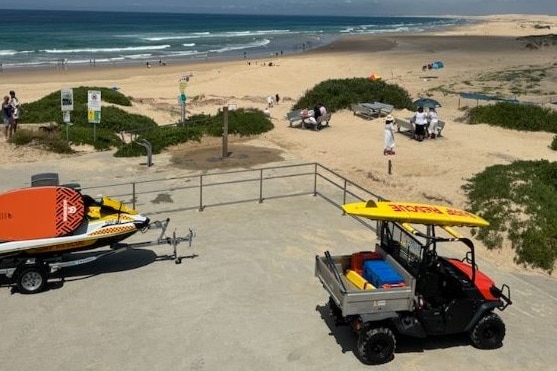 Life guard vehicles parked at a beach.