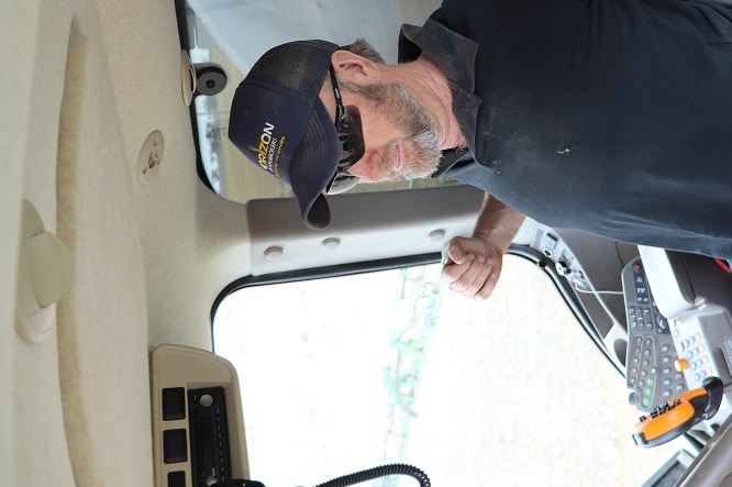 A farmer stretching in his tractor cab