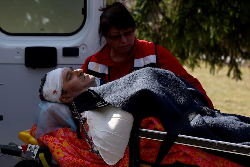 A medic transports an injured serviceman on a stretcher.