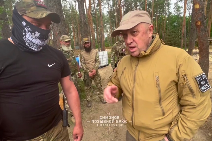 Head of Wagner Group military company Yevgeny Prigozhin speaks to fighters in a forest area.