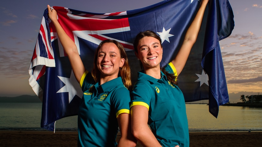 Zoe Poulis and Kiera Gazzard stand with an Australian flag during an Australian Artistic Swimming team announcement