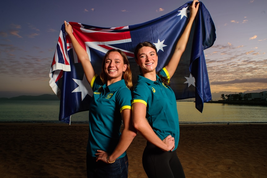 Zoe Poulis and Kiera Gazzard stand with an Australian flag during an Australian Artistic Swimming team announcement