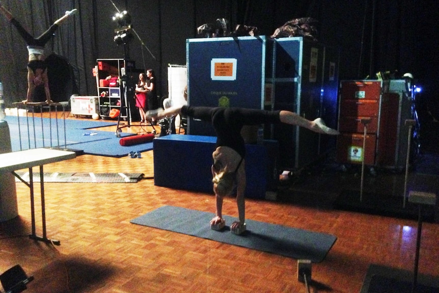 Gymnasts practice their routines backstage.