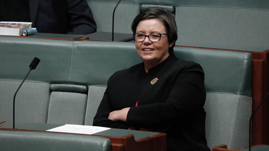 King sits with her arms folded in the House of Representatives.