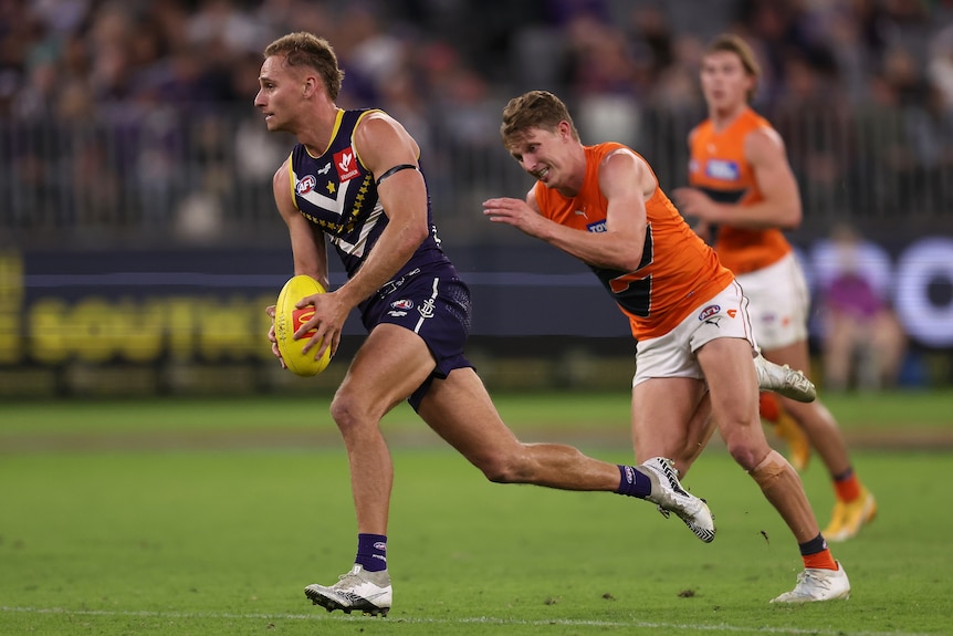 Fremantle's Will Brodie breaks clear of GWS' Lachie Whitfield