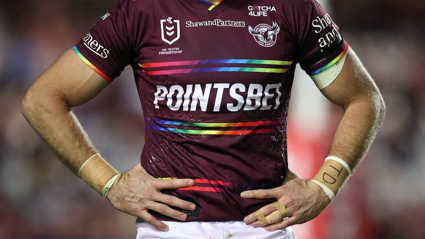 A Manly Sea Eagles jersey with rainbow bands above and below the sponsor name and on the cuffs and collar