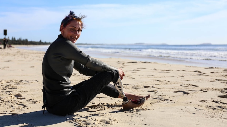 AJ sitting on the beach.