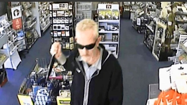 CCTV image of man in black jacket and sunglasses wielding knife