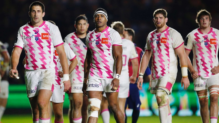 Stade Francais' Waisea Vuidarvuwalu (C) with dejected team-mates after a loss to Harlequins.