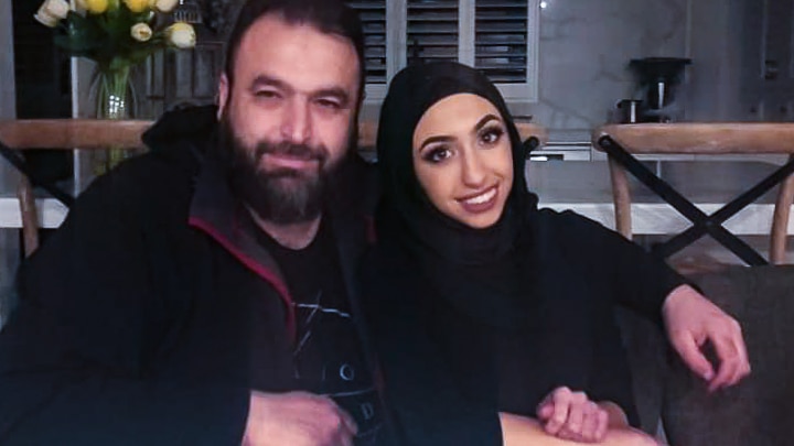 Zain Tiba with his arm around his daughter Ella Tiba at the kitchen table in their home. 