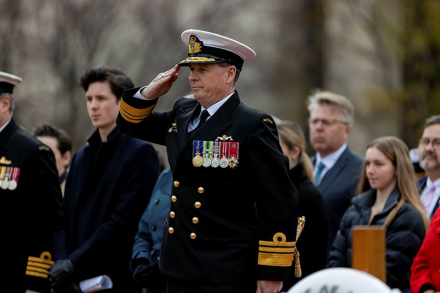 Mark Hammon saluting at a Naval ceremony. 