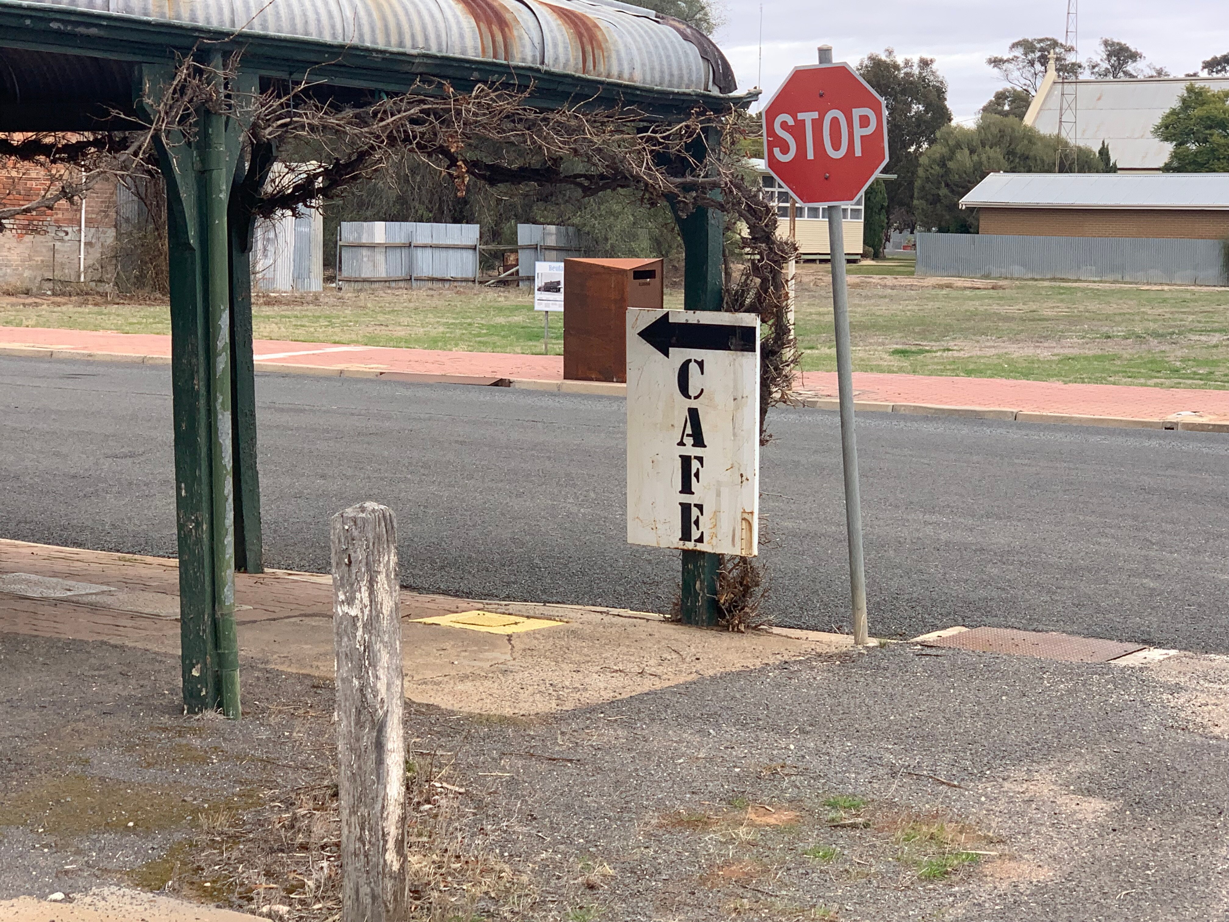 A sign pointing to a closed down cafe