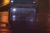 A bus is submerged in water at night