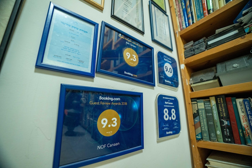 Several photo frames, some with blue background and yellow circle with numbers hung on a wall