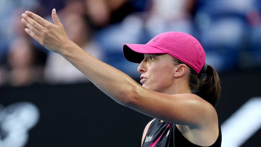 Iga Swiatek gestures with her left hand during an Australian Open match.
