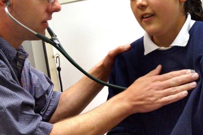 A doctor performs a physical on a child