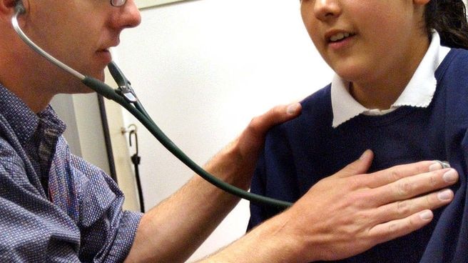 A doctor performs a physical on a child