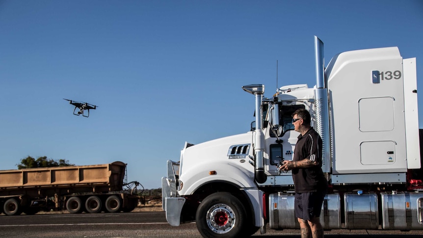 Truck driver flying remote-controlled drone