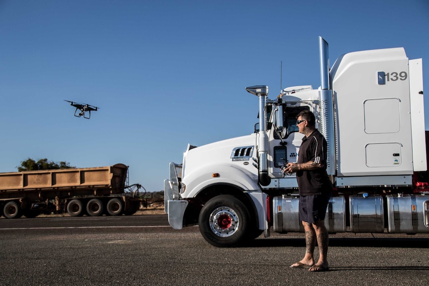 Truck driver flying remote-controlled drone