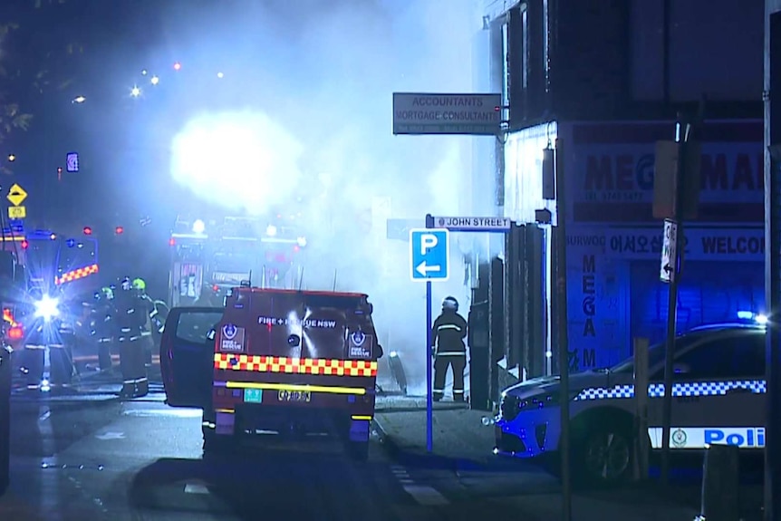 The scene of a fire at night, emergency vehicles on a street