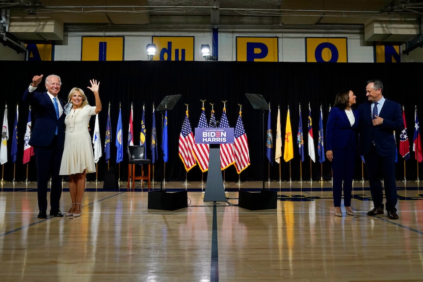 Joe Biden poses with his wife Jill, while Kamala Harris poses with her husband Doug on the other side of the picture