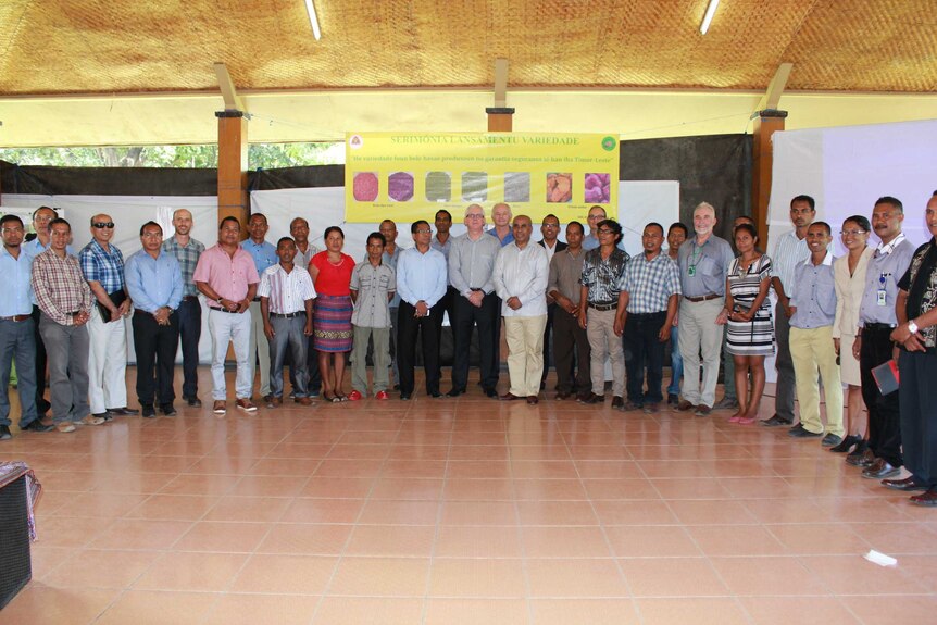 large semicircle of people pose for photo in Dili, East Timor