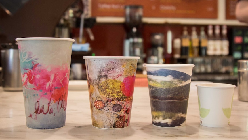 Four takeaway Coffee cups on a cafe bench