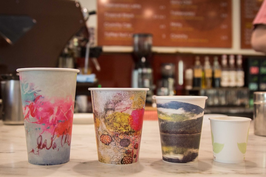 Four takeaway Coffee cups on a cafe bench