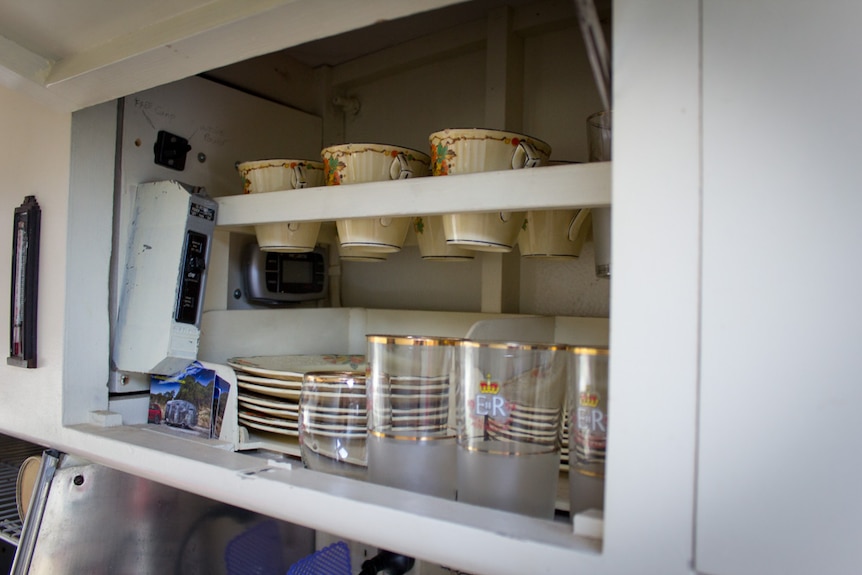 Vintage crockery inside a caravan cupboard.