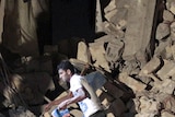 A man checks the rubble of the damaged house in Tripoli.