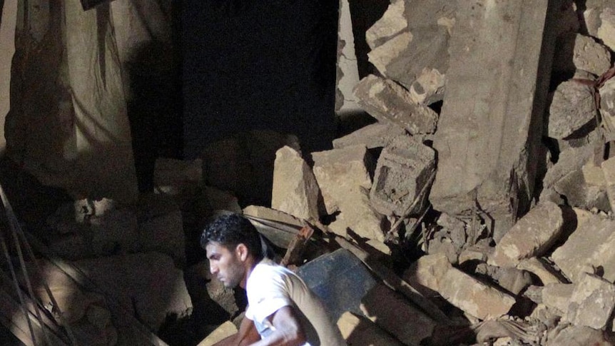 A man checks the rubble of a house in Tripoli