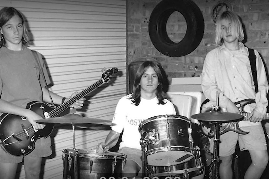 Black and white photo young boys in a band, drums and two guitars
