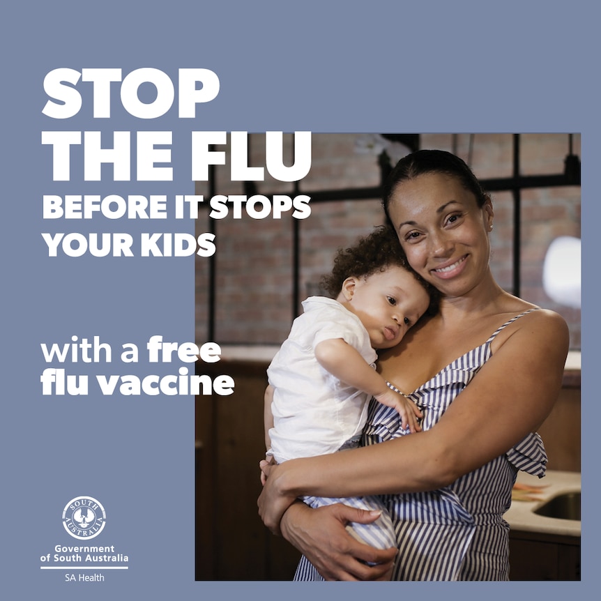 A woman holds her child in a health campaign advertisement.