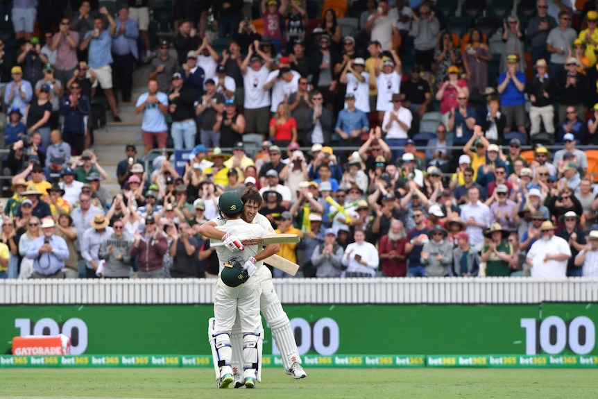 Joe Burns embraces Travis Head on the pitch as the Canberra crowd celebrates his century.