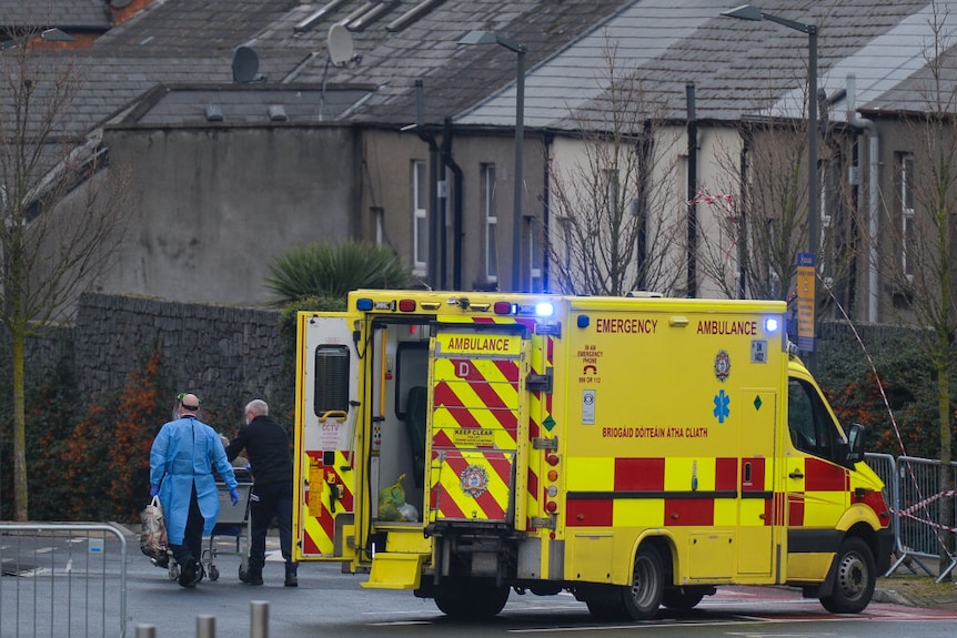 Paramedics help a patient next to an ambulance near the ED at a hospital in Dublin.