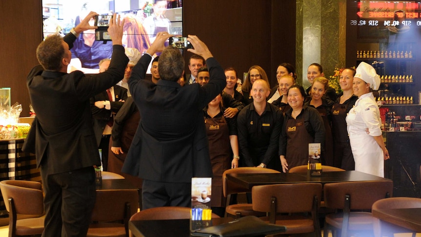 Staff pose for a photo ahead of the re-opening of the Lindt Cafe at Martin Place