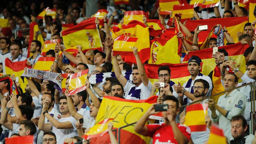 Real Madrid fans hold up Spanish flags
