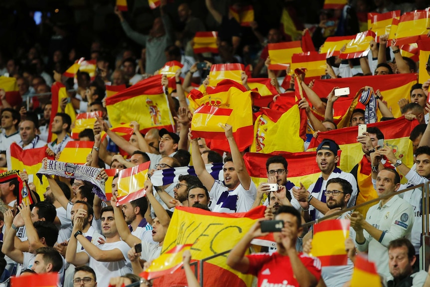 Real Madrid fans hold up Spanish flags