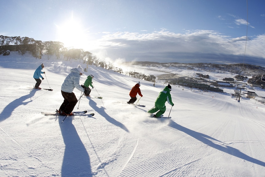 About six skiers skiing down the mountain