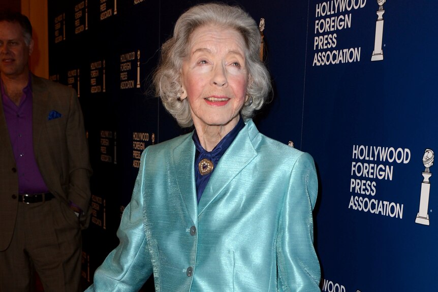 Marsha Hunt pictured in a satin blue jacket, with formal hair and make-up, at an event in her 90s.