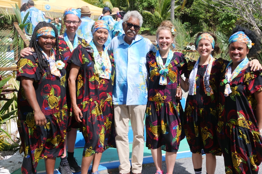 Group of people in colourful dresses smile for the camera