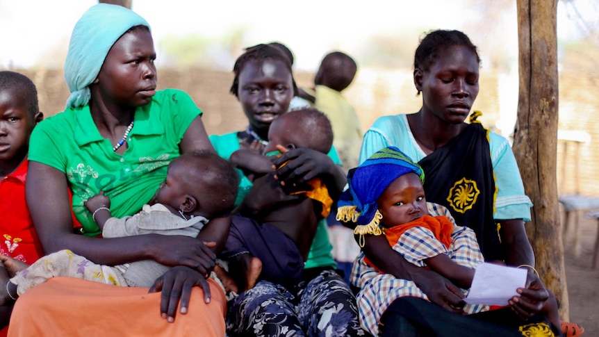 Women sit in a queue in Doro refugee camp.