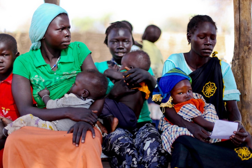 Women sit in a queue in Doro refugee camp.