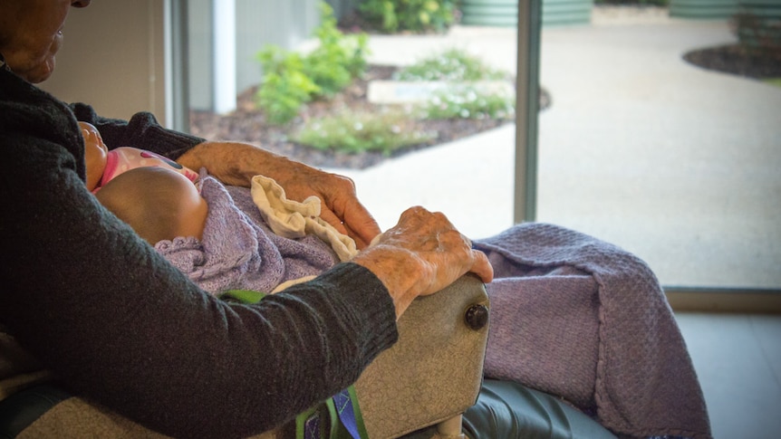 A dementia patient nurses dolls.