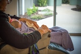 A dementia patient nurses dolls.